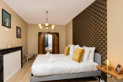 a bedroom with a bed and a fireplace at Lueur des Années Dorées in Carcassonne