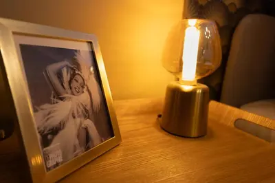 a lamp and a picture on a table next to a photo at Lueur des Années Dorées in Carcassonne