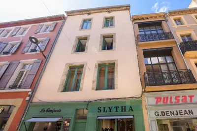 a row of buildings in a street with shops at Lueur des Années Dorées in Carcassonne