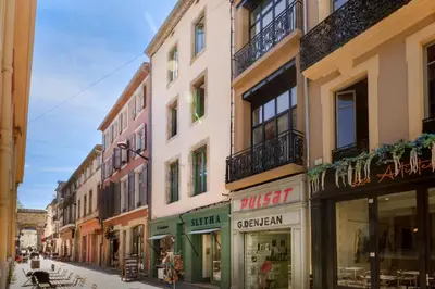 a group of buildings on a city street at Lueur des Années Dorées in Carcassonne