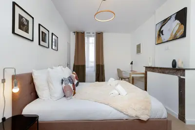 a bedroom with a large white bed with stuffed animals on it at MarQue Néo Art in Carcassonne