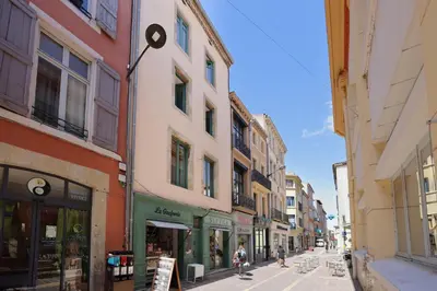 a street with buildings and people walking down the street at MarQue Néo Art in Carcassonne