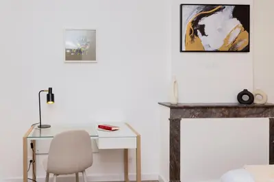 a desk with a chair next to a fireplace at MarQue Néo Art in Carcassonne