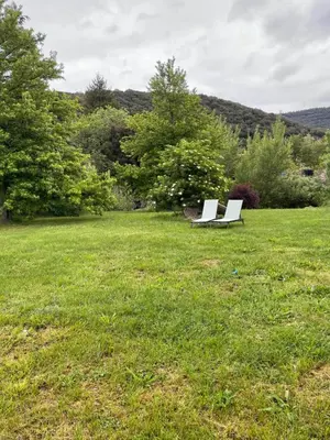 two white benches sitting in a field of grass at Moulin de l’Arcas in Prémian