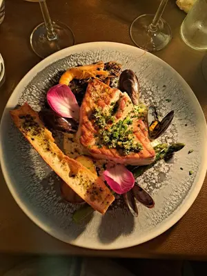 a plate of food with meat and vegetables on a table at Moulin de l’Arcas in Prémian