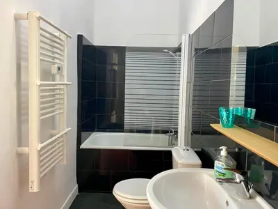 a bedroom with a bed and a dresser with a vase on it at Charmant T2 de 48m2 à 300m du centre ville in Lézignan-Corbières