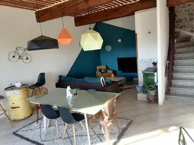 a living room with a table and a couch at Maison spacieuse, chaleureuse, Wifi et parking privé in Cases-de-Pène