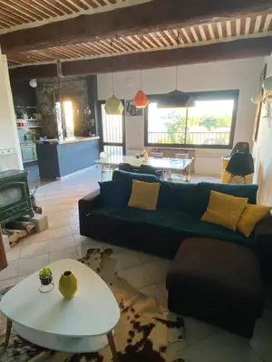 a living room with a blue couch and a table at Maison spacieuse, chaleureuse, Wifi et parking privé in Cases-de-Pène