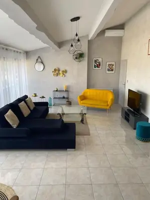 a living room with a blue couch and a yellow chair at Appartement spacieux, climatisé, parking privé, wifi et vue imprenable in Cases-de-Pène
