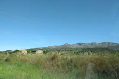 a field of grass with mountains in the background at Appartement spacieux, climatisé, parking privé, wifi et vue imprenable in Cases-de-Pène