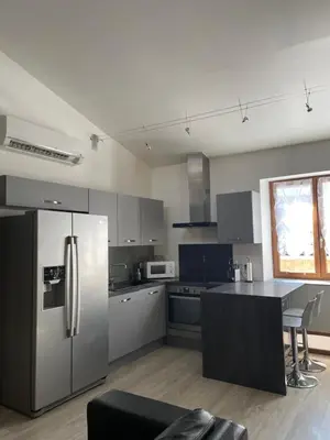 a kitchen with a stainless steel refrigerator and a table at Chez Tony et Laurie in Montbrun-des-Corbières