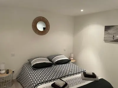 a bedroom with a bed and a mirror on the wall at Chez Tony et Laurie in Montbrun-des-Corbières