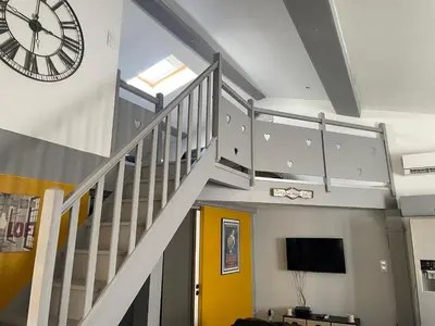 a staircase with a clock and a yellow door at Chez Tony et Laurie in Montbrun-des-Corbières