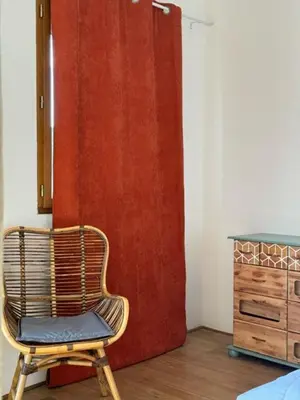 a chair sitting in front of a red door at La vue de la calade in Peyriac-de-Mer