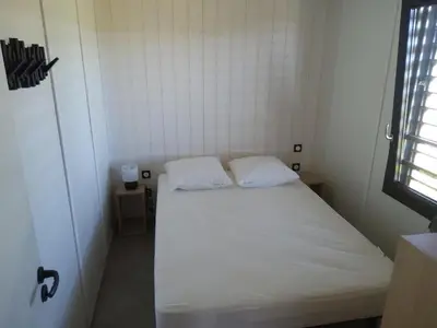 a small bedroom with a white bed with two pillows at Chalet 3 chambres, piscine, lac à 100m - Olonzac - FR-1-783-1 in Olonzac