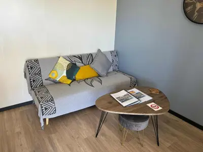 a living room with a couch and a table at Chalet confortable 2 chambres près du lac de Jouarres - FR-1-783-8 in Olonzac
