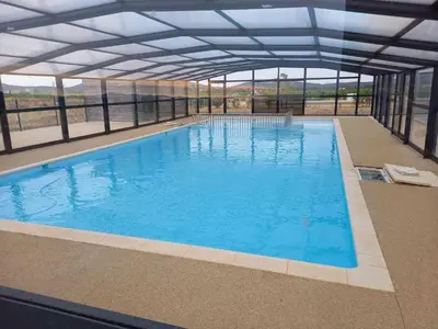 a large swimming pool with a large ceiling at Chalet confortable 2 chambres près du lac de Jouarres - FR-1-783-8 in Olonzac