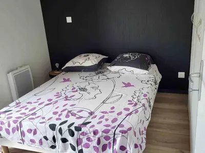 a bedroom with a bed with a purple and white comforter at Chalet confortable 2 chambres près du lac de Jouarres - FR-1-783-8 in Olonzac