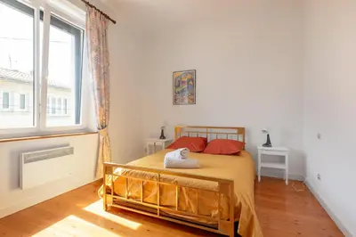 a bedroom with a bed and a large window at la Voûte in Carcassonne