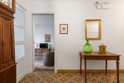 a hallway with a table with a green vase on it at la Voûte in Carcassonne