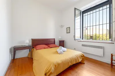 a bedroom with a bed with yellow sheets and a window at la Voûte in Carcassonne