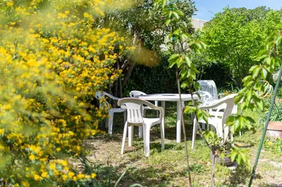 a table and chairs in a garden with yellow flowers at la Voûte in Carcassonne
