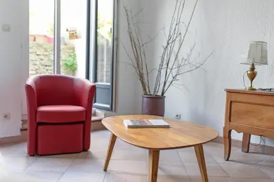a living room with a red chair and a table at la Voûte in Carcassonne