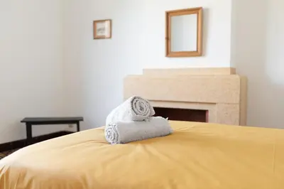 a bed with towels on it with a fireplace at la Voûte in Carcassonne