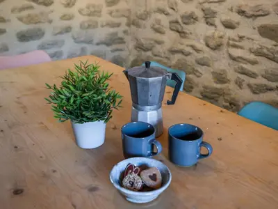 a table with a coffee maker and a plate of food at Le Pigeonnier de Villefloure in Montréal