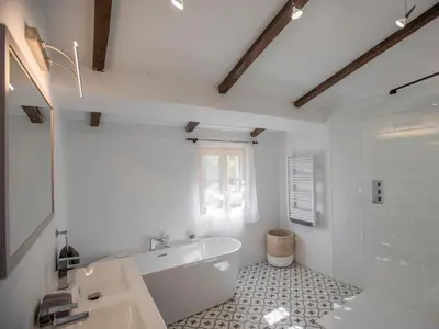 a white bathroom with a tub and a sink at Le Pigeonnier de Villefloure in Montréal
