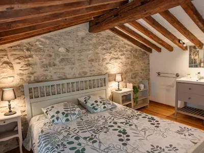 a bedroom with a bed and a stone wall at Le Pigeonnier de Villefloure in Montréal