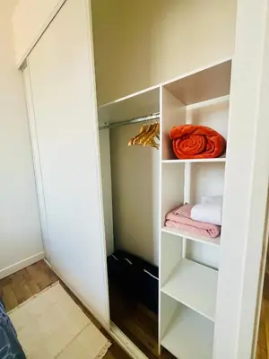 a walk in closet with white shelves and towels at Appartement Chez Rose in Narbonne