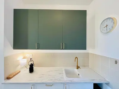 a kitchen with a sink and a clock on the wall at Appartement Chez Rose in Narbonne