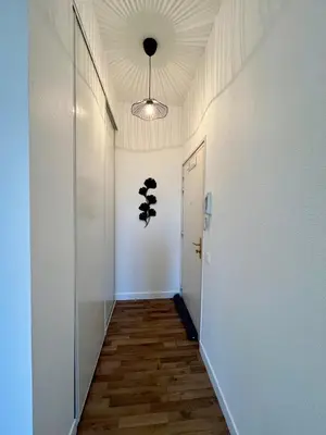 a hallway with a white wall and a ceiling at Appartement Chez Rose in Narbonne