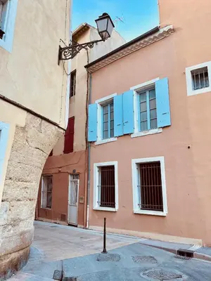 a building with blue windows and a street light at Appartement Chez Rose in Narbonne