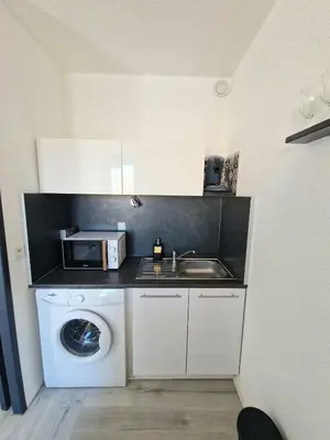 a kitchen with a washing machine and a microwave at L'Escapade Gruissanaise, appartement 1 chambre, loggia, climatisation, wifi avec piscines de mi-mai à mi-septembre dans résidence in Gruissan