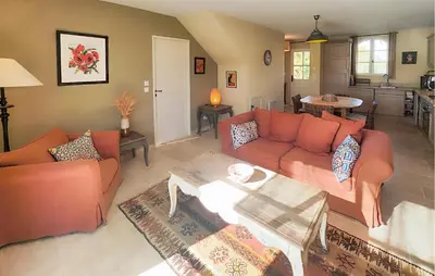 a living room with orange couches and a table at Awesome Home In Saint-Laurent-De-La-Ca in Saint-Laurent-de-la-Cabrerisse