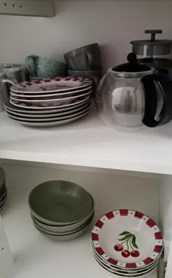 a kitchen shelf with plates and dishes on it at Cozy self contained modern home near Carcassonne in Badens
