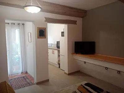 a living room with a television and a kitchen at Cozy self contained modern home near Carcassonne in Badens