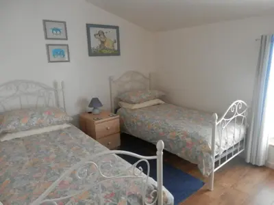 a bedroom with two beds and a night stand with a nightstand at Maison de Laura in Salsigne