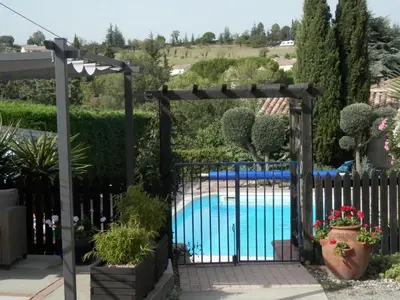 a gate with a pool in a garden at Maison de Laura in Salsigne