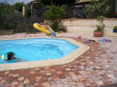a young boy playing in a swimming pool with a inflatable at Maison de Laura in Salsigne