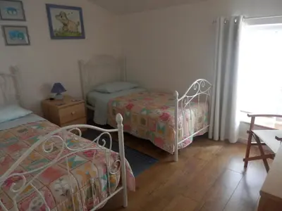 a bedroom with two beds and a table and a window at Maison de Laura in Salsigne