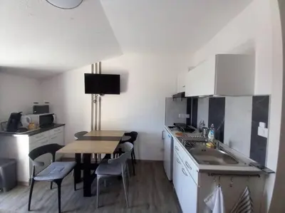 a kitchen with a table and a sink and a table and chairs at Gîte avec piscine - 4 personnes - Pays Cathare in Cuxac-Cabardès