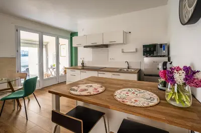 a kitchen with a wooden table with two plates on it at Oasis Urbaine Narbonne in Narbonne