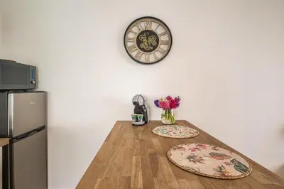 a kitchen with two plates on a wooden table with a refrigerator at Oasis Urbaine Narbonne in Narbonne
