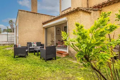 a patio with chairs and a table in a yard at Oasis Urbaine Narbonne in Narbonne