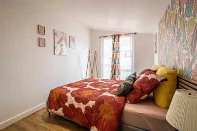 a bedroom with a bed with a comforter and a window at Oasis Urbaine Narbonne in Narbonne
