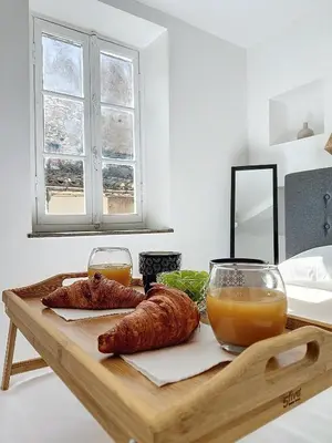 a table with two croissants and a glass of orange juice at Le Iéna in Carcassonne