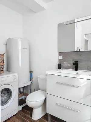 a bathroom with a toilet and a sink and a washing machine at Le Iéna in Carcassonne